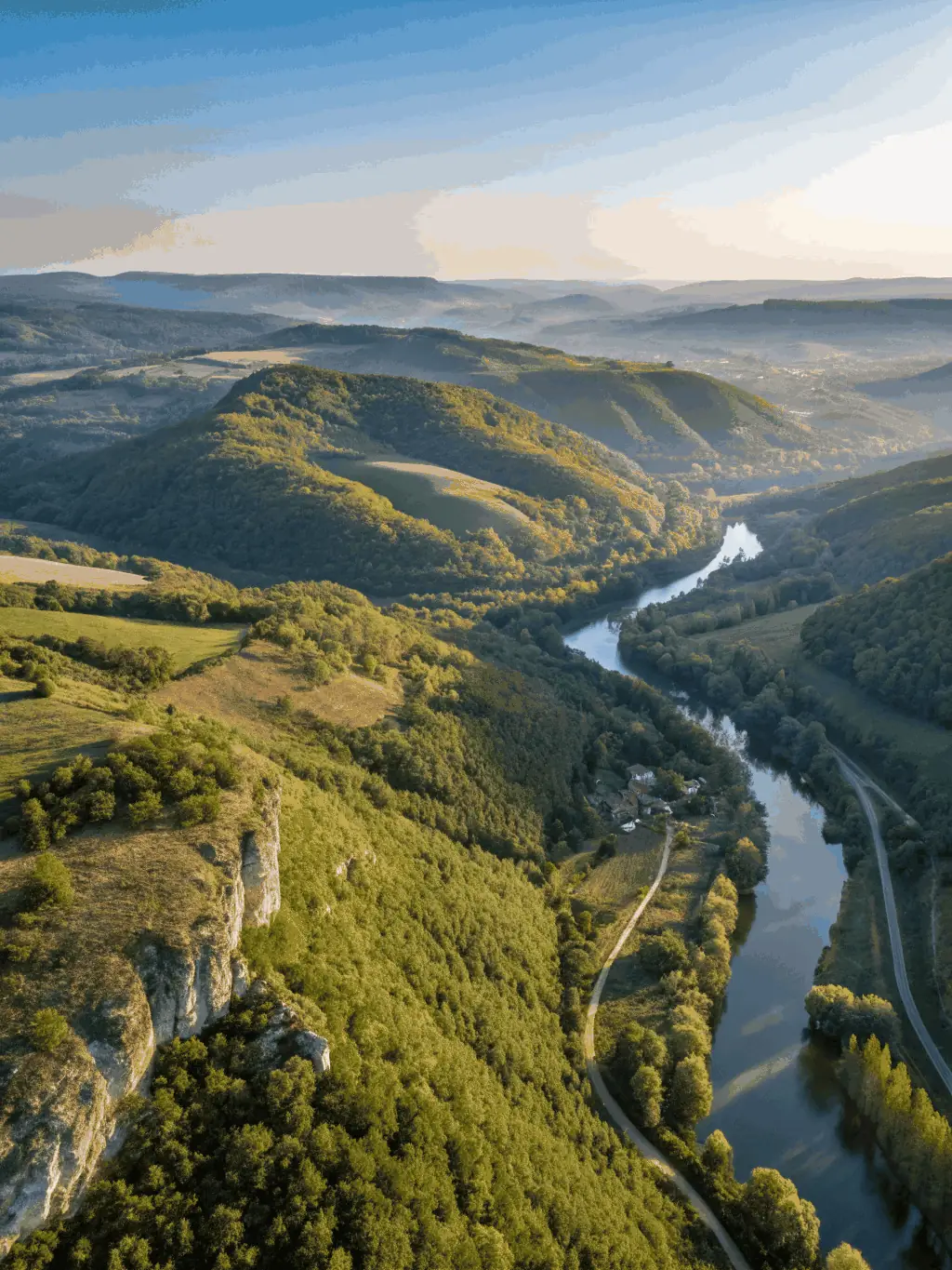 An aerial shot of an ultralight aircraft soaring over the Montmoreau region, emphasizing the beauty of the landscape and the freedom of flight.